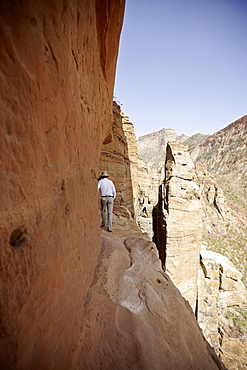 Man on a narrow path to monolithic church Abuna Yemata Guh, Hawzien, Tigray Region, Ethiopia