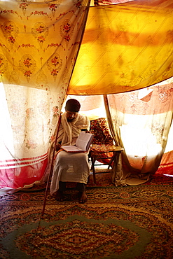 Singing teacher and priest reading a book, monastery Debre Damo, near Adigrat, Tigray Region, Ethiopia