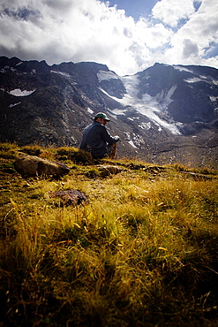 Man sitting on a mountain meadow, rear of Gschnitz Valley (ca. 2413 m), Stubai Alps, Tyrol, Austria