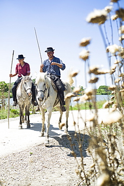 Gardians and their Camargue horse in front of their Manade, near Aigues-Mortes, Camargue, Gard, Languedoc-Roussillon, France