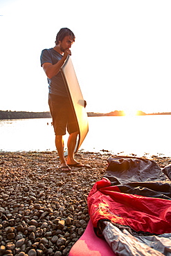 Young man inflating his camping mat, Freilassing, Bavaria, Germany