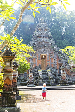 Boy in front of temple Pura Durga Kutri, Kutri, Ubud, Bali, Indonesia