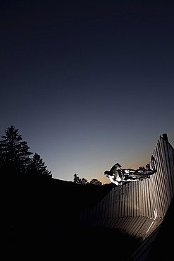 Mountain biker passing wallride, Oberammergau, Bavaria, Germany