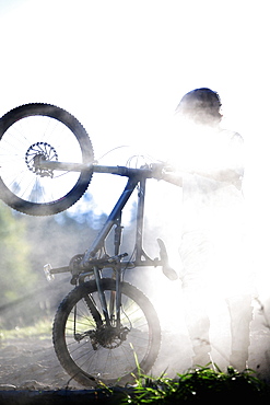 Young man holding a mountain bike, Oberammergau, Bavaria, Germany