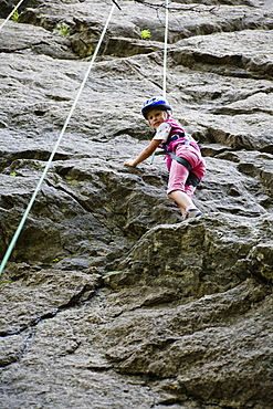 Girl (8-9 years) climbing on a rock, Upper Bavaria, Bavaria, Germany