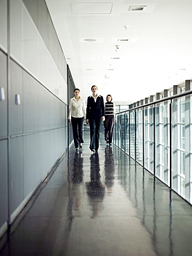 Three businesswomen walking along corridor, Munich, Bavaria, Germany