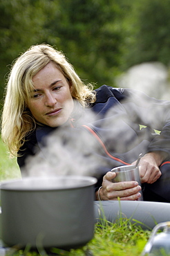 Camping, cooking pot and blonde woman on a meadow, Franconian Switzerland, Bavaria, Germany, Europe