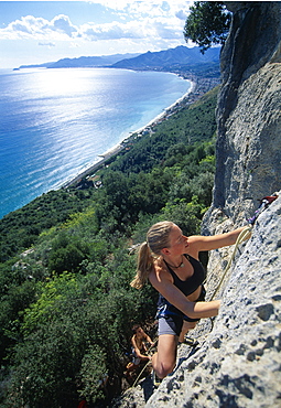 Young woman climbing on rockface, Finale, Liguria, Italy