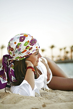 Young woman relaxing on the beach, profile