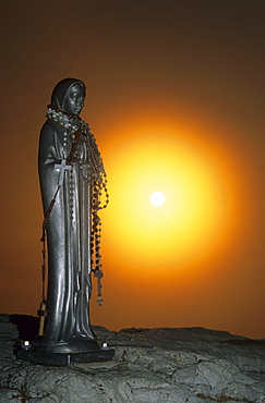 Madonna with rosary and the rising sun as backlight, Piz Boe, Sella Mountains, Dolomites, South Tyrol, Italy