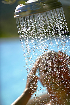 Woman taking a shower, bay of Porto Vecchio, Southern Corse, France