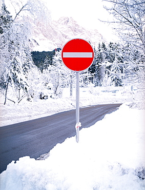 Stop sign in the snow on mountain road, Germany, Bavaria