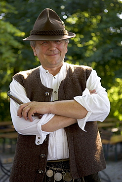 Older Bavarian man with pipe wearing traditional clothes, Munich, Bavaria