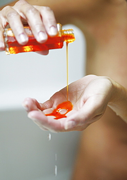 Young woman with body oil on hands