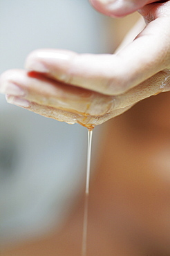 Young woman with body oil on hands