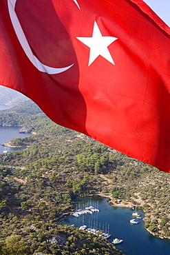 The flag of Turkey in front of the small bay Kapi Creek, Fethiye Bay, Turkey, Europe