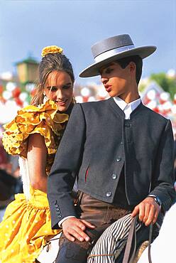 Couple in traditional costumes on a horse, Feria de Abril, Sevilla, Andalusia, Spain, Europe