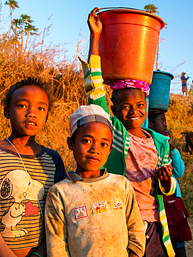 Children come from fetching water, at Ampefy, Merina tribe, highlands, Madagascar, Africa