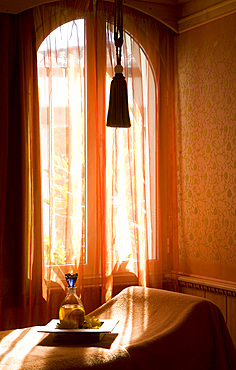 Interior shot of san oil bottle on tray, in a Spa treatment room kept in faded, orange hues. Madrid, Spain.