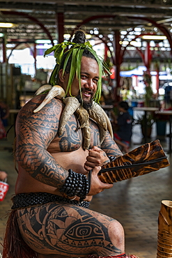 A Tahitian 'warrior' with tattoos welcomes visitors to the "Marché Papeete" market hall, Papeete, Tahiti, Windward Islands, French Polynesia, South Pacific