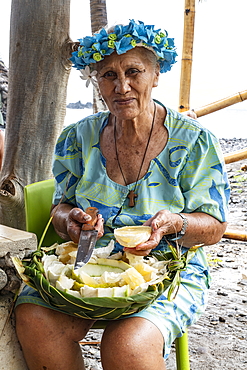 Elderly woman offers pieces of tropical fruit, Hokatu, Ua Huka, Marquesas Islands, French Polynesia, South Pacific