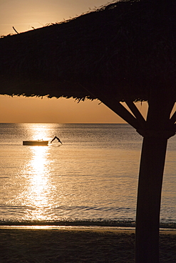 Silhouette of thatched parasol and young woman jumping from bathing platform into the water in front of Ong Lang Beach, Ong Lang, Phu Quoc Island, Kien Giang, Vietnam, Asia