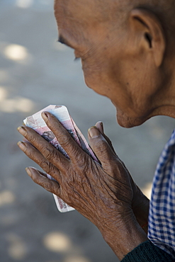 Hands of elderly woman offering money to Buddhist monks as alms, Oknha Tey Island, Mekong River, near Phnom Penh, Cambodia, Asia