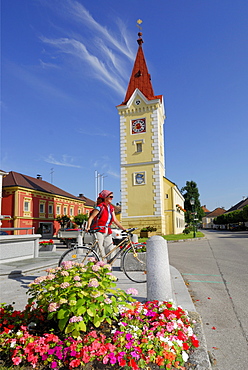 Woman with bicycle near a church, Wallsee-Sindelburg, Mostviertel, Lower Austria, Austria