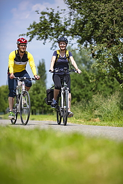 Young man and young woman ride mountain bikes, Tauberbischofsheim, Baden-Wuerttemberg, Germany, Europe