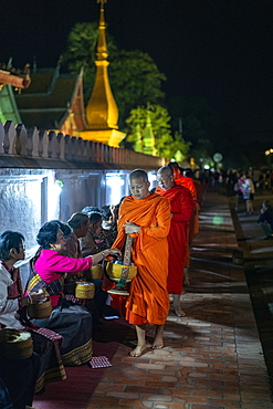 Barefoot monks collect early morning food and drink alms (sai bat), Luang Prabang, Luang Prabang Province, Laos, Asia