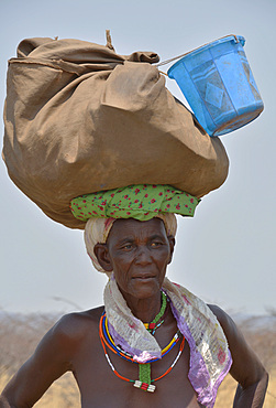 Angola; in the western part of the province of Cunene; Woman on the street; with luggage on his head