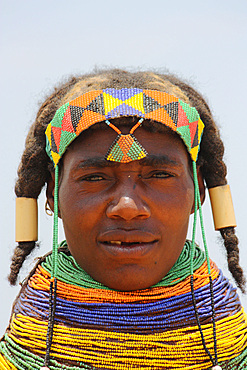 Angola; Huila Province; small village near Chibia; Muhila woman with typical neck and headdress; massive choker made of pearl necklaces and earth