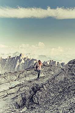 Woman with camera stands on a mountain near Lünersee, Vorarlberg, Austria, Europe