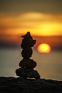 Stone sculpture by the sea at sunset