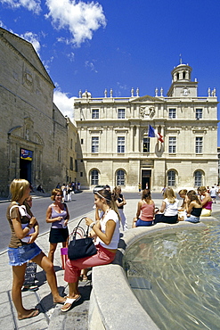 Young women at a fountain in front of the town hall, Place de la Republique, Arles, Bouches-du-Rhone, Provence, France, Europe