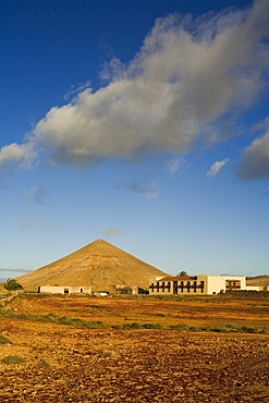 The extinct volcano Montana Oliva behind the historical building Casa de Los Coroneles, La Oliva, Fuerteventura, Canary Islands, Spain, Europe