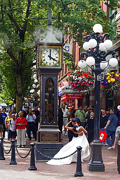 Wedding Couple kissing each other in front of steam clock in Gastown, Vancouver City, Canada, North America