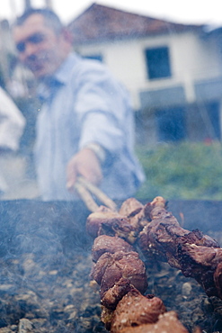 Man grilling Espetada beef skewer kebabs at a religious festival, Ponta Delgada, Madeira, Portugal