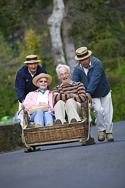 Elderly couple enjoying a Monte Toboggan Run, Funchal, Madeira, Portugal