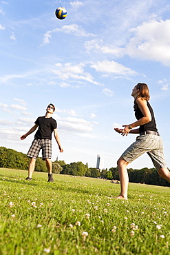 Young people playing volleyball on a meadow, Leipzig, Saxony, Germany