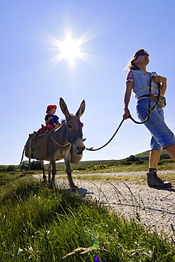 A donkey on a lead, Mother and daughter family-hiking with a donkey in the Cevennes mountains, France