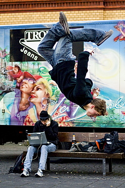 Teenager performing a somersault, Young man sitting with his laptop, Leisure, Ingolstadt, Bavaria, Germany