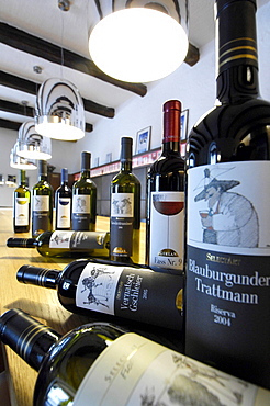 Wine bottles beneath bright lamps at the wine cellars Girlan, Bozen, South Tyrol, Italy, Europe