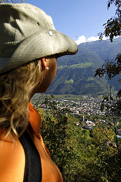 Young woman looking at the village Naturno in a valley, Val Venosta, South Tyrol, Italy, Europe