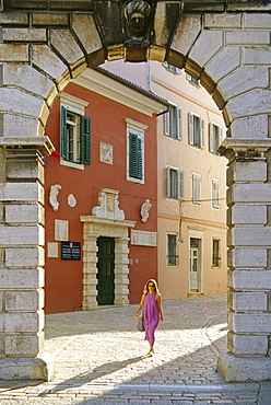 A woman and venetian Balbi gate at the Old Town of Rovinj, Croatian Adriatic Sea, Istria, Croatia, Europe