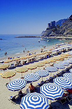 People and sunshades on the beach, medieval tower, Monterosso al Mare, Cinque Terre, Liguria, Italian Riviera, Italy, Europe