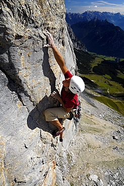 Climber at Schuesselkar rock face in the sunlight, Tyrol, Austria, Europe