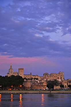 View over river Rhone to city walls, cathedral Notre-Dame-des-Doms and papal palace in the afterglow, Avignon, Vaucluse, Provence, France, Europe