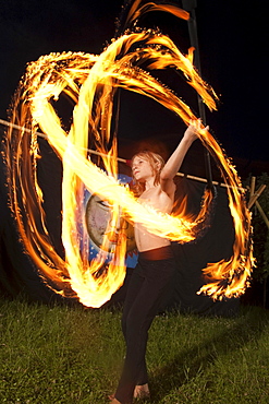 Boy juggling with fire at night, Austria