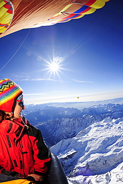 Woman in hot-air balloon enjoying view to Pala range in winter, aerial photo, Pala range, Dolomites, Venetia, Italy, Europe